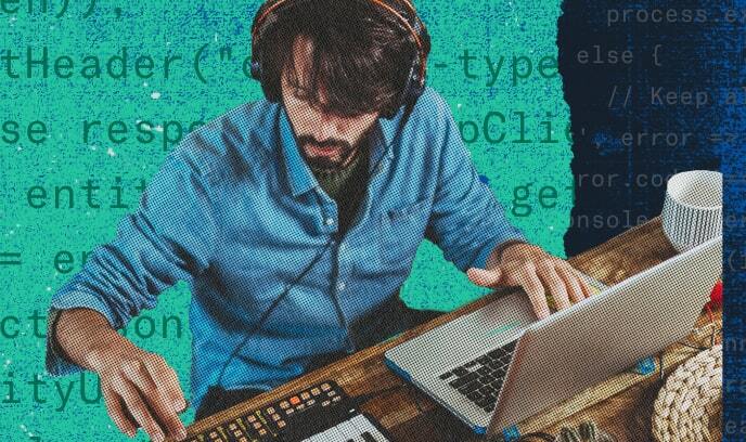 パソコンとミュージックキーボードの両方で作業している男性ミュージシャンの画像